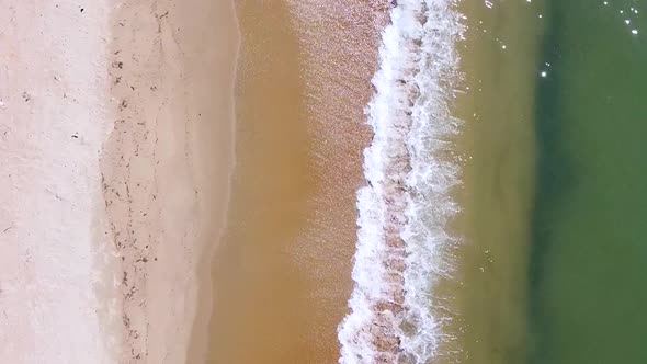Vertical orientation video: Small waves on the sand beach