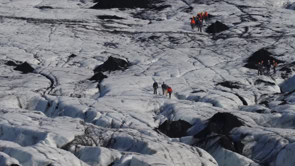 Unrecognizable Tourist Groups Over Massive Glacier