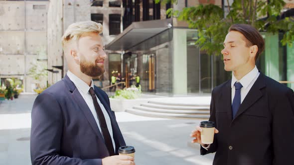 Confident businessman and his colleague in front of modern office building. alt