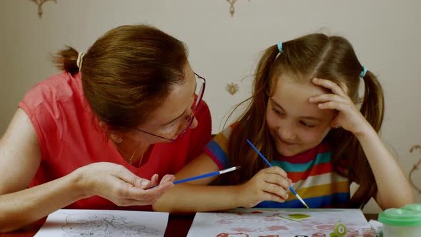 Grandmother Teaches Her Granddaughter How to Paint