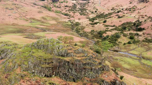 Aerial View Over Hills Towards Mountains