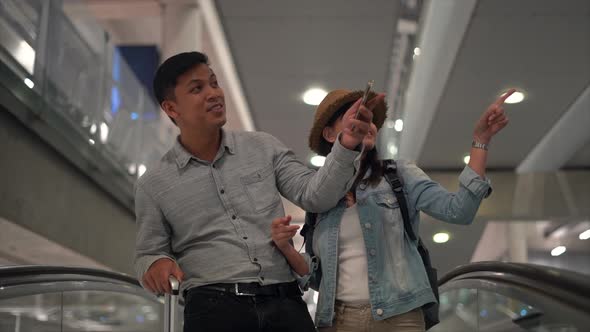 Couple Asian people walking in airport terminal waiting for  flight boarding.