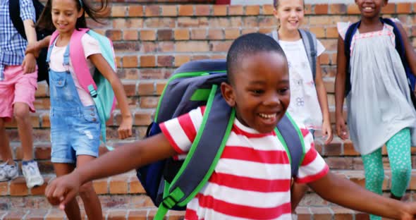 Group of kids getting down from staircase alt