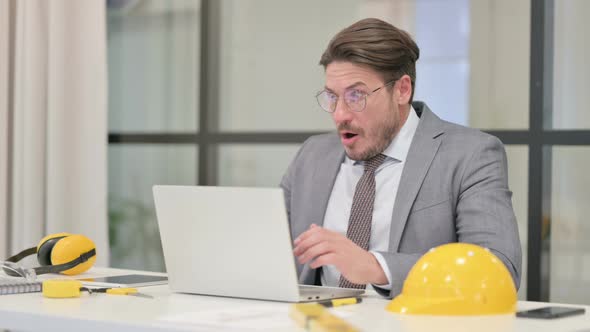 Middle Aged Engineer Reacting to Loss While using Laptop alt