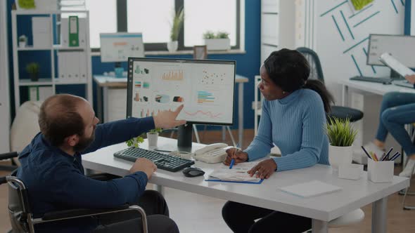 Diverse Team Working with Financial Graphs Discussing Solution for Project alt