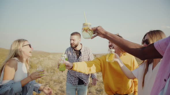 Emotional Happy Friends Stand in Circle Laugh Clink Glasses with Cocktails and Drink These Drinks alt