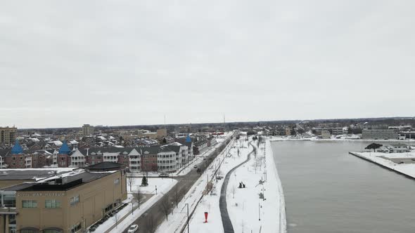 Aerial view of harbor on edge of city with large apartment complex on a cloudy winter day.