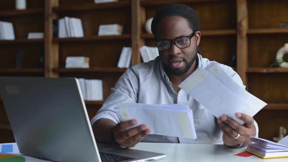 Smiling AfricanAmerican Guy Holding Envelopes alt