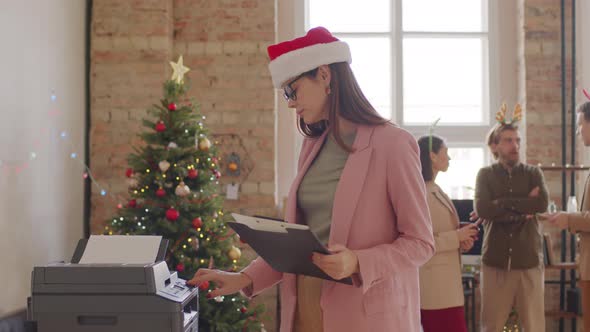Portrait of Happy Businesswoman in Santa Hat Posing in Office on Christmas alt