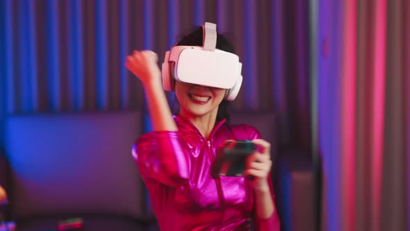 Young asian woman is using virtual reality headset. Neon light studio portrait alt