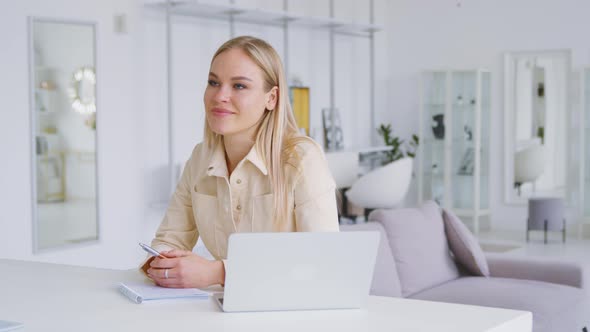 Attractive woman with laptop interviewing colleague in white room alt