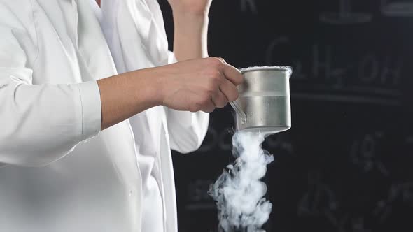 Chemical Show Using Liquid Nitrogen a Thick White Vapor Coming Out of a Glass Held in the Hands of a alt