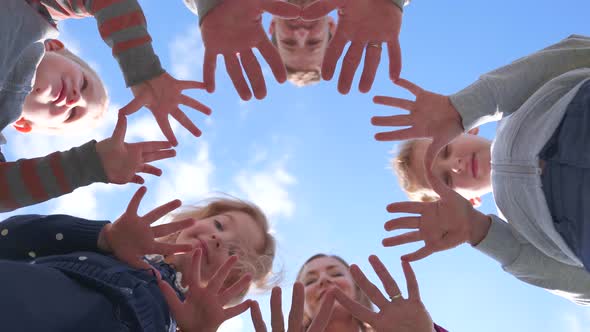A Friendly Large Family Makes a Circle Shape Out of the Palms of Their Hands.