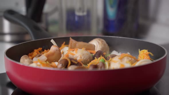 Cooking Vegetables in a Frying Pan Mushrooms Peas Onions Carrots alt