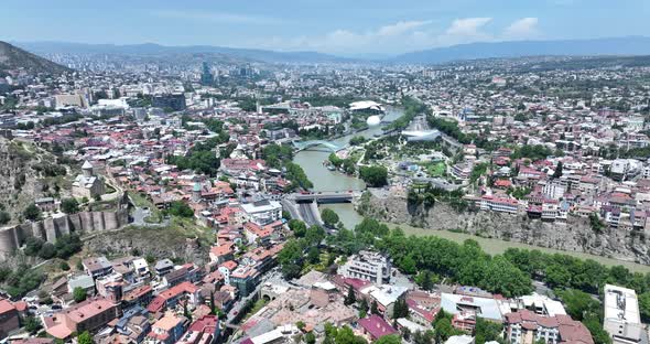 Aerial view of Tbilisi city central park and Bridge of Peace. Beautiful cityscape of old Tbilisi at alt