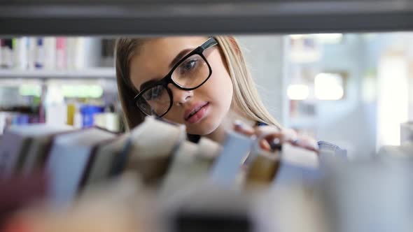 Bookstore. Woman Looking For Education Book On Shelf alt