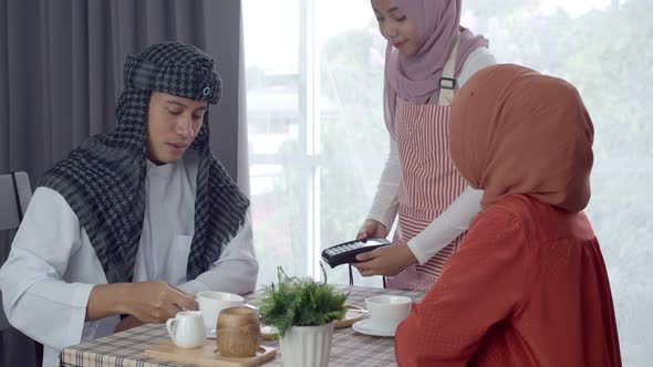 Young muslim man use smart watch contactless payment in coffee shop