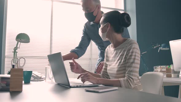 Business people working in the office and wearing face masks