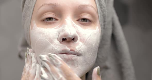 Portrait of Young Woman with a Towel on Her Head Washing Cleansing Face with Organic Foamy Cleanser