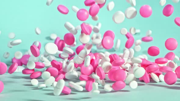 Super Slow Motion Shot of Falling Colorful Pills on Light Green Background at 1000Fps. alt