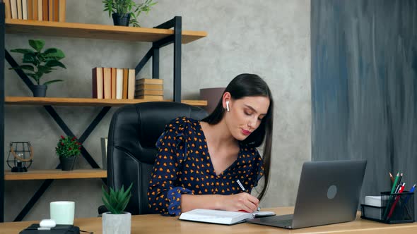 Woman in home office study online remote video call webcam laptop, listen teacher writes in notebook alt