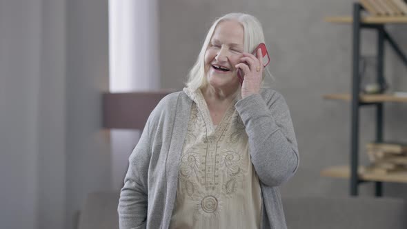 Portrait of Happy Old Caucasian Retiree Picking Up the Phone Talking and Smiling alt
