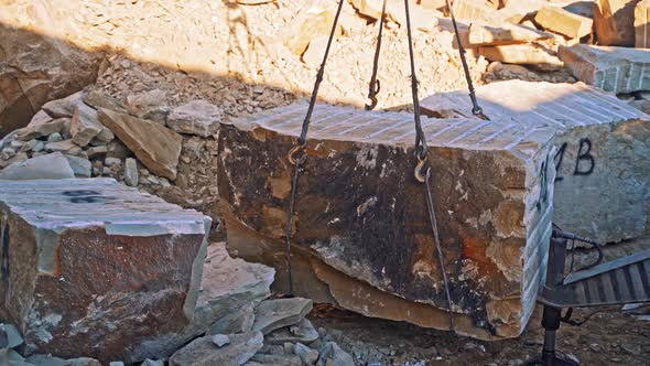 Crane lifting heavy rock. Heavy natural granite stone blocks stacked ...