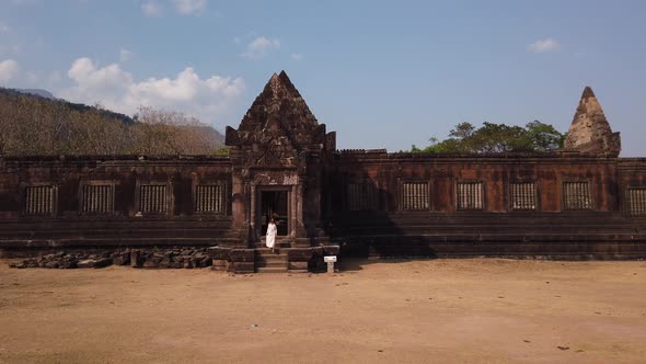 Woman going out the Khmer palace in Vat Phou ruined Hindu Temple complex. Ancient culture of Laos