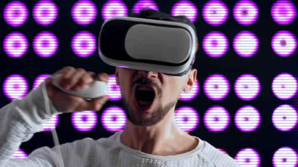 Caucasian Man in Virtual Reality Helmet Brushes Teeth with a Modern Joystick