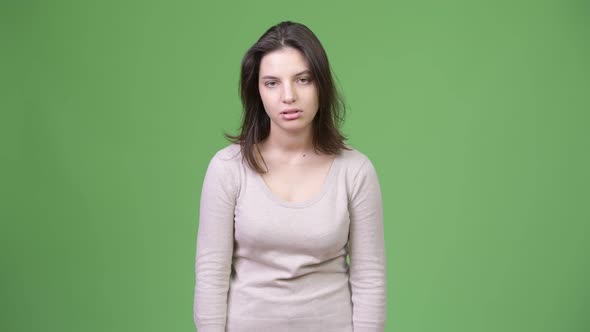 Young Beautiful Woman Looking Bored Against Green Background alt