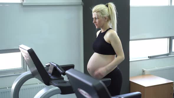 Pregnant Woman Training Treadmill Machine in Gym Cardio Exercises on Running Simulator alt