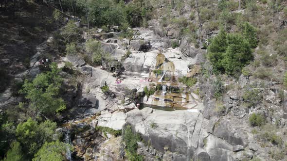 Visitors at Fecha de Barjas waterfall, Peneda-Gerês National Park. Aerial pullback