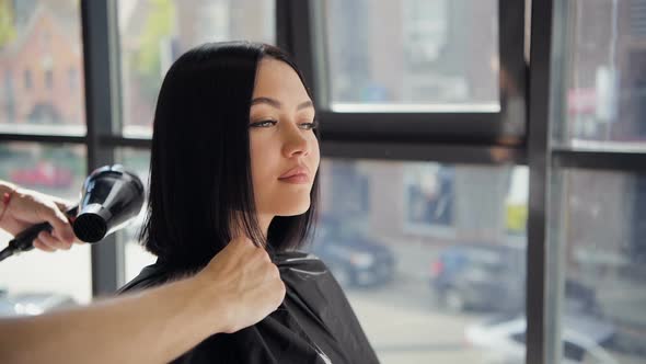 Hair Stylist Using Dryer on Woman Hair and Cleaning Her Neck with a Napking in Salon After Making a alt