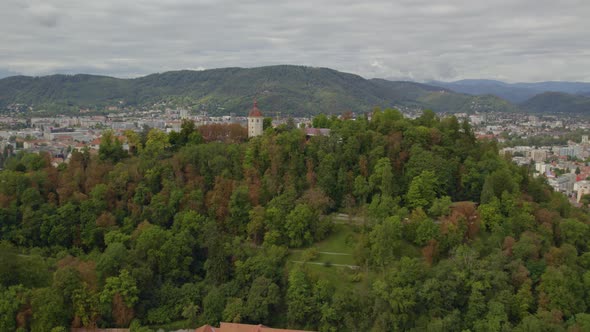 Aerial view heading towards Graz's Schloßberg dolomite inner city hilltop woodland in Graz Austria alt