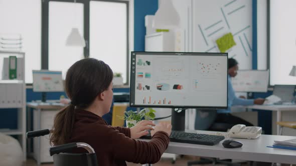 Paralysed Financial Expert Sitting in Wheelchair Analysing Economy Statistics alt