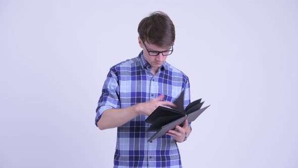 Happy Young Handsome Hipster Man Reading Book with Eyeglasses alt