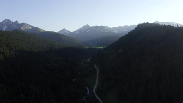 Aerial view of Arkhyz mountains summer landscape forest rural road mountain river, Caucasus Russia