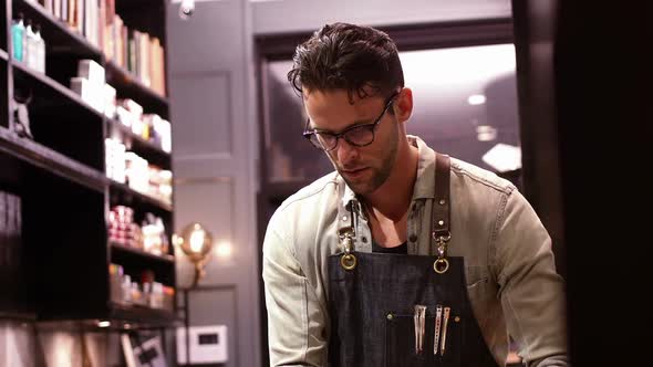 Male barber working in barber shop alt