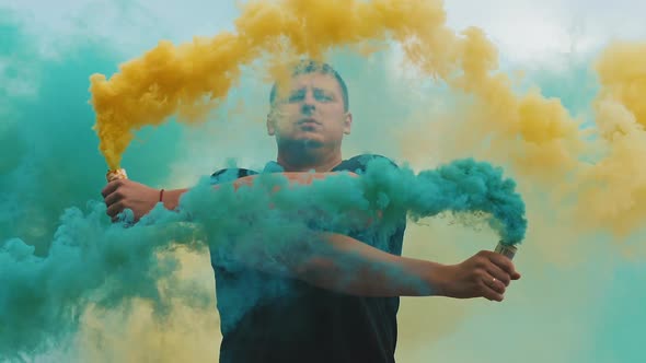 Man with Yellow and Blue Colored Smoke Bomb alt