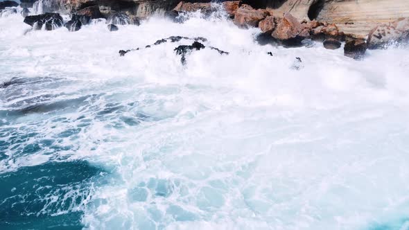 Aerial View of Waves Break on Rocks in a Blue Ocean Sea Waves on Beautiful Beach Bird's Eye View of alt
