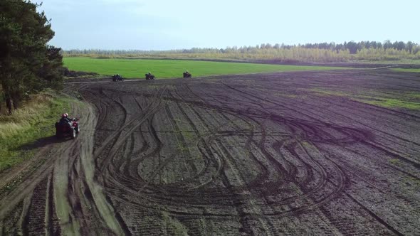 The Movement of ATVs on a Plowed Field in the Direction of the Forest Aerial Photography
