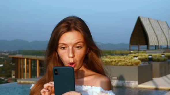 Portrait of Surprised and Happy Woman Enjoy Success or Win on Mobile Phone alt