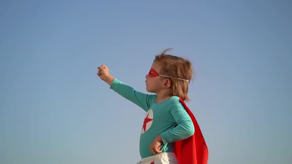 Superhero child against blue sky background