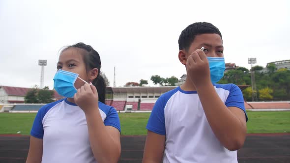 Asian Boy And Girl Takes Off Mask At Stadium alt