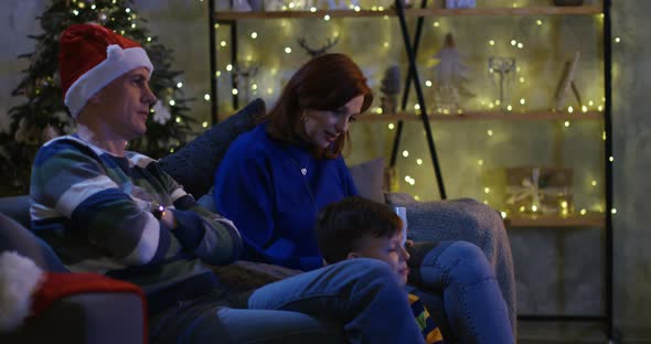 Family Watching Television at Christmas Eve alt