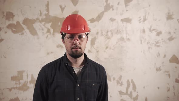 Portrait of a Steward, a Worker Stands on the Background of a Repaired Wall alt