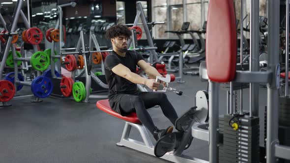 Intensive Workout in Gym Man Doing Cable Row Exercise alt