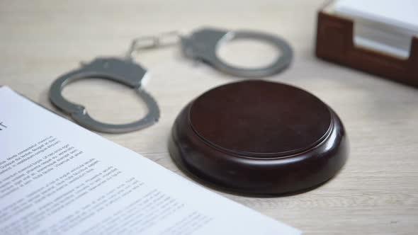 Handcuffs on Table, Gavel Striking on Sound Block, Crime Punishment, Law Order alt