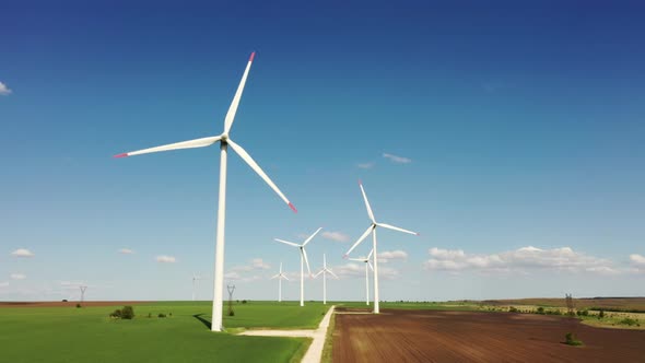 Wind Farm on the Background of Pure Blue Sky and Green Grass