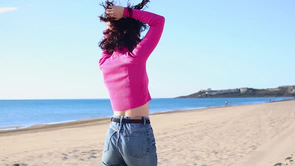 Young Woman Dancing Alone on the Beach and Laughing